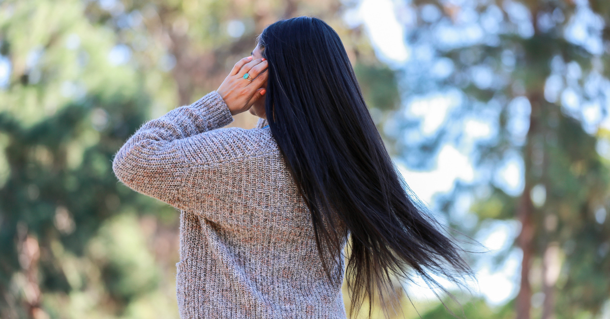 自然の中を歩くロングヘアの女性