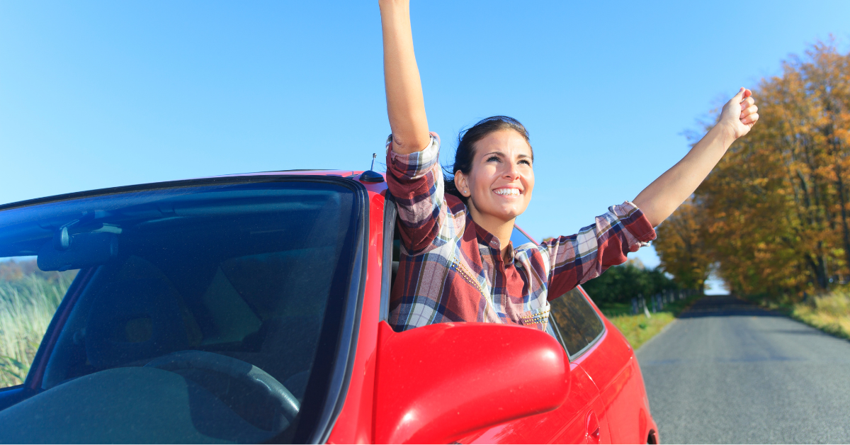 赤い車から身を乗り出す女性